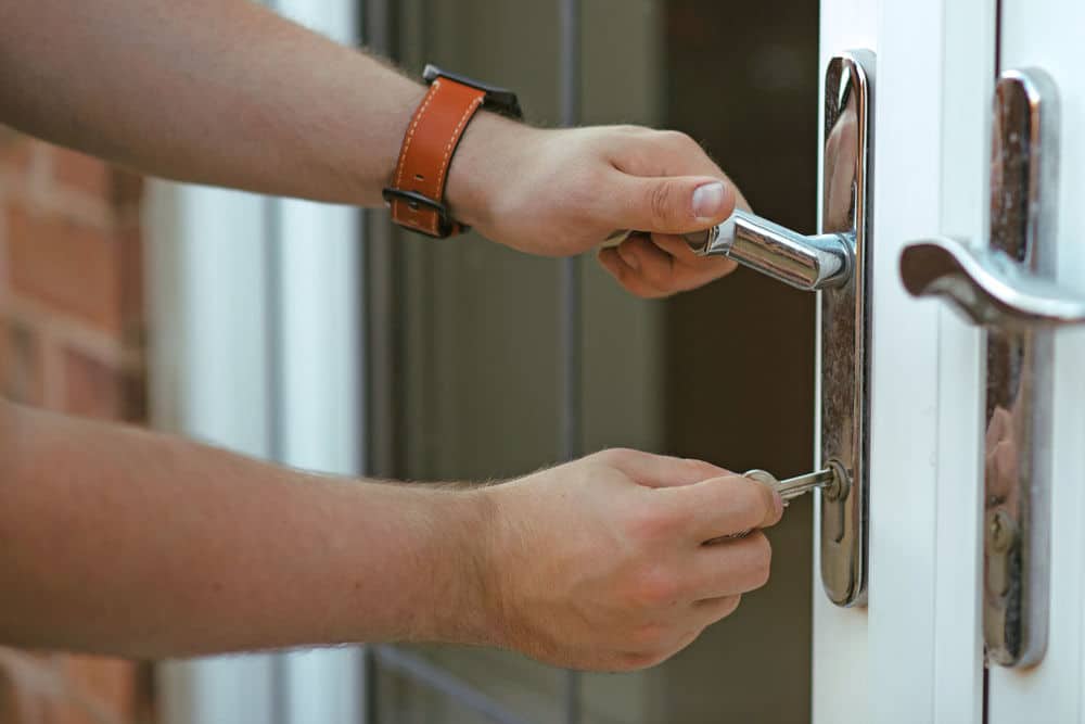 person putting key in the door lock